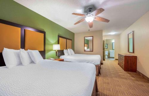a hotel room with two beds and a ceiling fan at Extended Stay America Suites - Evansville - East in Evansville