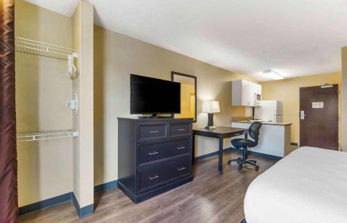 Habitación con cama y escritorio con TV. en Extended Stay America Select Suites - Tampa - North - USF - Attractions, en Tampa