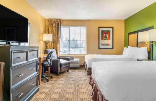 a hotel room with two beds and a desk at Extended Stay America Suites - Auburn Hills - University Drive in Auburn Hills
