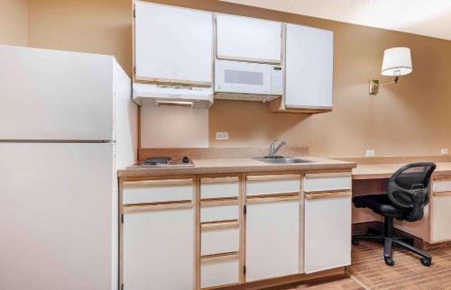 a kitchen with a white refrigerator and a sink at Hawthorn Extended Stay by Wyndham DFW Airport North in Irving