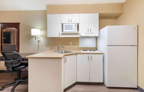 a kitchen with white cabinets and a white refrigerator at Extended Stay America Suites - Fresno - North in Fresno