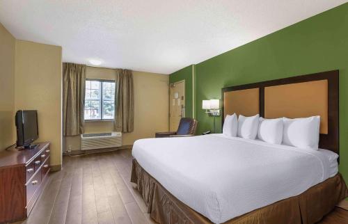 a hotel room with a large bed and a television at Extended Stay America Suites - Fresno - North in Fresno