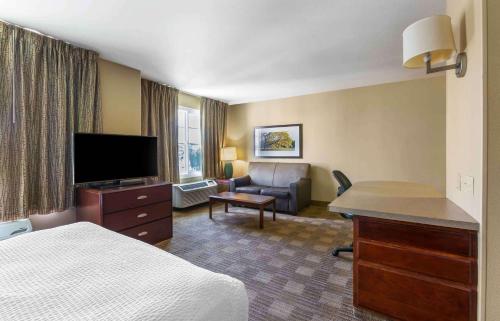 a hotel room with a bed and a desk with a television at Extended Stay America Suites - Atlanta - Gwinnett Place in Duluth