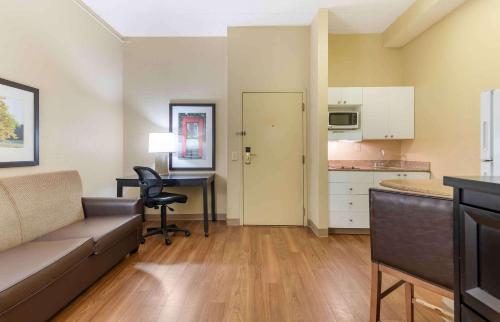 a living room with a couch and a table and a kitchen at Extended Stay America Suites - Atlanta - Gwinnett Place in Duluth