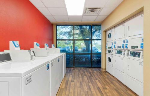 a laundry room with white washing machines and a red wall at Extended Stay America Suites - Atlanta - Gwinnett Place in Duluth