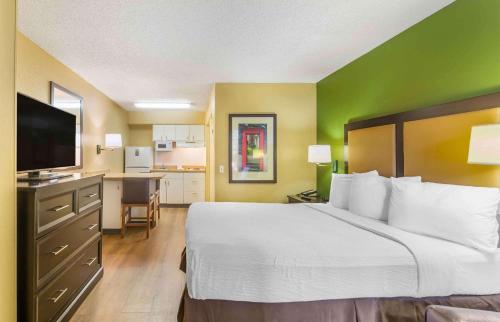 a hotel room with a large bed and a kitchen at Extended Stay America Suites - Fort Lauderdale - Tamarac in Fort Lauderdale