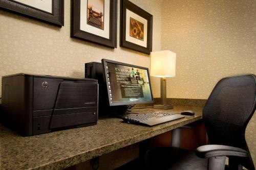 een bureau met een computer en een monitor en toetsenbord bij Drury Inn & Suites Valdosta in Valdosta