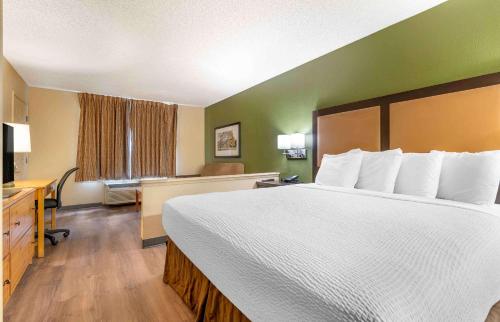 a hotel room with a large bed and a desk at Extended Stay America Suites - Portland - Tigard in Tigard
