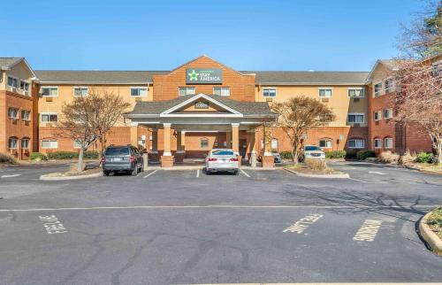 a building with cars parked in a parking lot at Extended Stay America Select Suites - Chesapeake - Churchland Blvd in Chesapeake