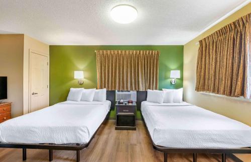 2 łóżka w pokoju z zielonymi ścianami w obiekcie Extended Stay America Suites - Chesapeake - Churchland Blvd w mieście Chesapeake