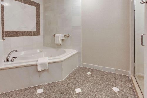 a white bathroom with a tub and a shower at Drury Inn & Suites West Des Moines in West Des Moines