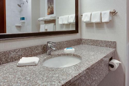 a bathroom with a sink and a mirror at Drury Inn & Suites West Des Moines in West Des Moines