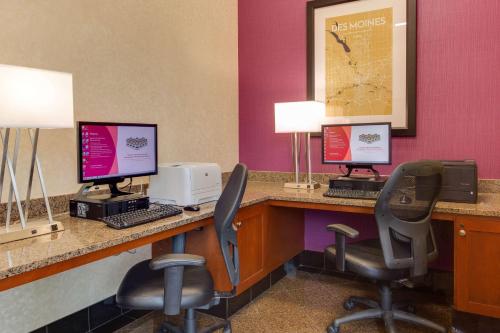 a lobby with two computer monitors and two chairs at Drury Inn & Suites West Des Moines in West Des Moines