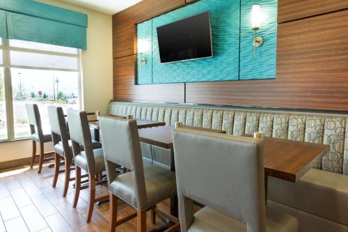 a dining room with a table and chairs and a television at Drury Inn & Suites Colorado Springs Near the Air Force Academy in Colorado Springs