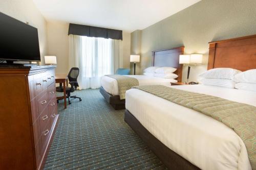 a hotel room with two beds and a flat screen tv at Drury Inn & Suites Colorado Springs Near the Air Force Academy in Colorado Springs