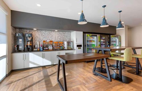a restaurant with two tables and chairs and a refrigerator at Extended Stay America Premier Suites - Phoenix - Chandler - Downtown in Chandler