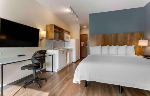 a hotel room with a bed and a desk and a television at Extended Stay America Premier Suites - Phoenix - Chandler - Downtown in Chandler