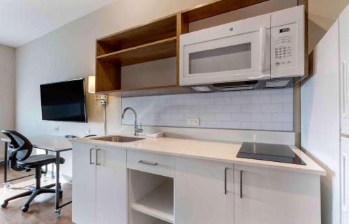 a white kitchen with a sink and a microwave at Extended Stay America Premier Suites - Phoenix - Chandler - Downtown in Chandler