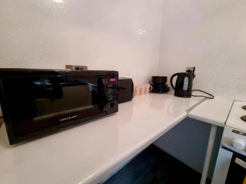a microwave sitting on top of a counter at Sleek & Stylish - E15 Apartment With Parking in London