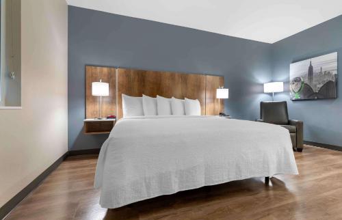 a bedroom with a large bed and a chair at Extended Stay America Premier Suites - Austin - Austin Airport in Austin