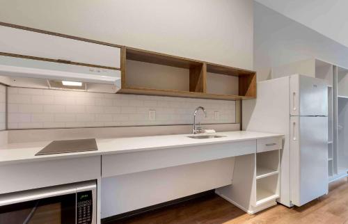 a white kitchen with a sink and a refrigerator at Extended Stay America Premier Suites - Austin - Austin Airport in Austin