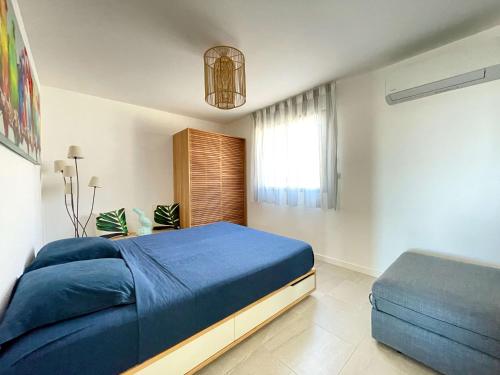 une chambre avec un lit bleu et une fenêtre dans l'établissement Appartamentu A Leccia, à Grosseto-Prugna