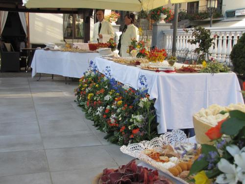 a buffet line with tables of food and flowers at Hotel Ristorante Combolo in Teglio
