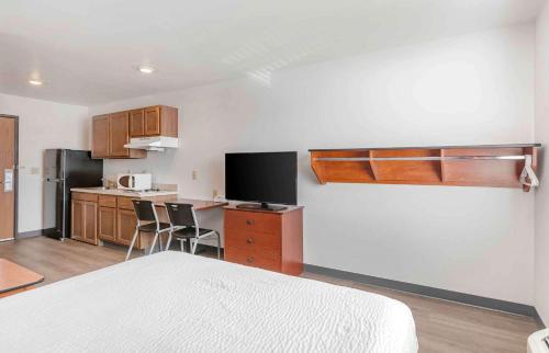 a room with a bed and a kitchen with a counter at Extended Stay America Select Suites - Omaha - Southwest in Omaha