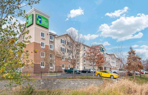 a yellow car parked in front of a building at Extended Stay America Select Suites - Kansas City - Stadium in Independence