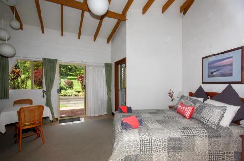 a bedroom with a bed and a table and a window at A view of Mount Warning in Uki