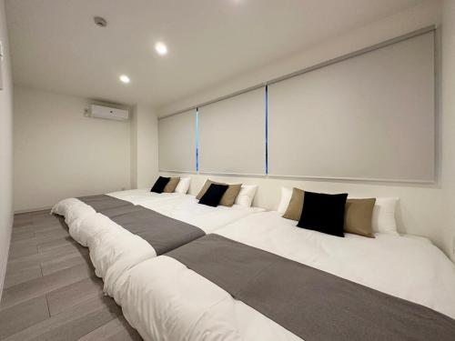 three large white beds in a room at bHOTEL Nikke - Apt for 10Ppl Ideal for Big Group in City Center in Ōsukachō