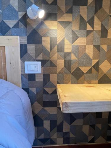 a bedroom with a tiled wall with a bed at Lattrazionedelgeco in Terni