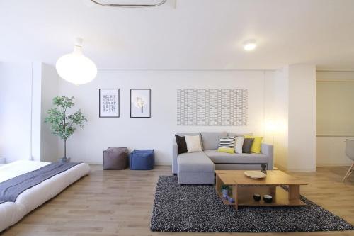 a living room with a couch and a coffee table at b hotel Nikke - 2BR Apt for 10ppl near Hondori Shopping in Hiroshima