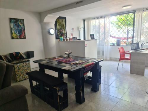 sala de estar con mesa y cocina en Hostal Casa Yare en Rodadero