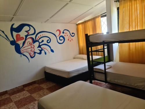 a room with two bunk beds and a painting on the wall at Hostal Casa Yare in Rodadero