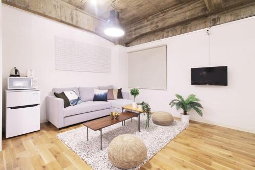 a living room with a couch and a table at b hotel Nikke - 1BR Apt for 10ppl near Hondori Shopping in Hiroshima