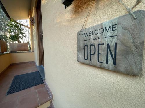 ein Schild mit der Aufschrift „Willkommen, wir haben geöffnet“ an einem Haus in der Unterkunft Lattrazionedelgeco in Terni