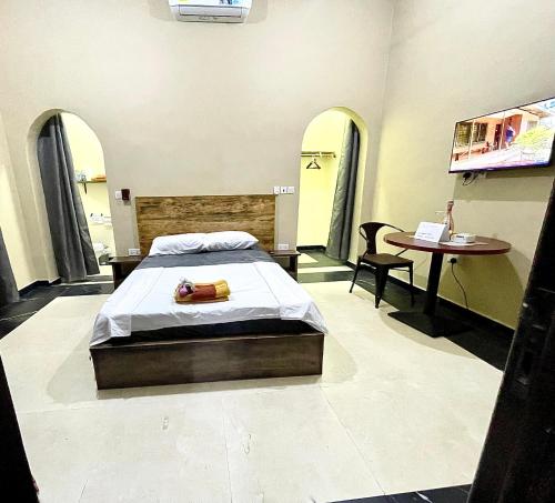 Accra Luxury Apartments At The Sanga Estates في آكرا: غرفة نوم فيها سرير وطاولة فيها