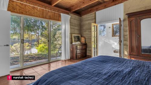 une chambre avec un lit et de grandes fenêtres dans l'établissement Bermagui Jewel on the Lake Cuttagee Bermagui Wifi provided, à Bermagui