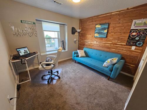 un soggiorno con divano blu e sedia di Fully furnished home with lots of natural lighting and personal office space a Fayetteville