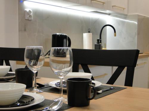a table with two wine glasses on top of it at Stare Miasto Elbląg Bulvar in Elblag