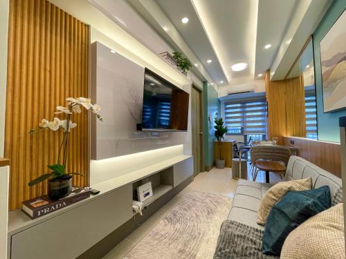 een woonkamer met een bank en een tv bij SMDC Fame Residence luxurious family suite condo near mrt in Manilla
