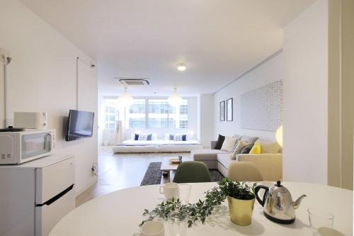 Nikkei building hatchobori, Room: #401 - Vacation STAY 17684v في هيروشيما: مطبخ أبيض وغرفة معيشة مع طاولة