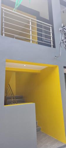 een kamer met een gele en witte muur en een trap bij ZEG in Suva