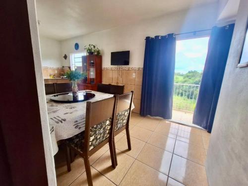 a kitchen with a table and chairs and a window at Pousada JP in Vila Nova do Sul