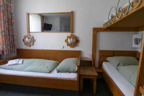 a bedroom with two beds and a mirror at Hotel & Restaurant Elbschetal in Wetter