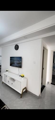een witte woonkamer met een tv aan de muur bij Marina furnished Apartment in Nairobi