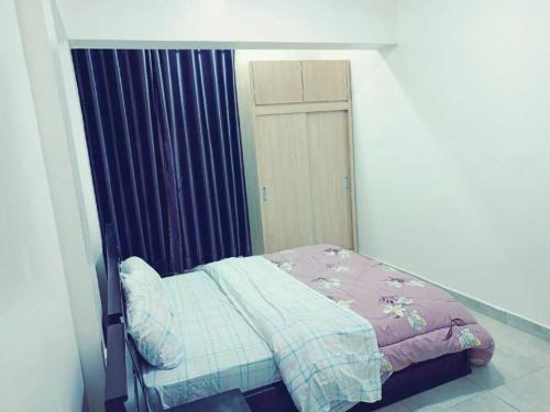 ein kleines Bett in einem Schlafzimmer mit lila Vorhängen in der Unterkunft Simon's Place in Kigali