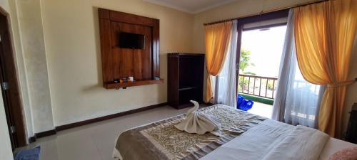 - une chambre avec un lit et une grande fenêtre dans l'établissement Lembongan Made Inn, à Nusa Lembongan