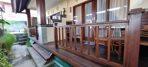une terrasse en bois avec une table et des chaises dans l'établissement Lembongan Made Inn, à Nusa Lembongan